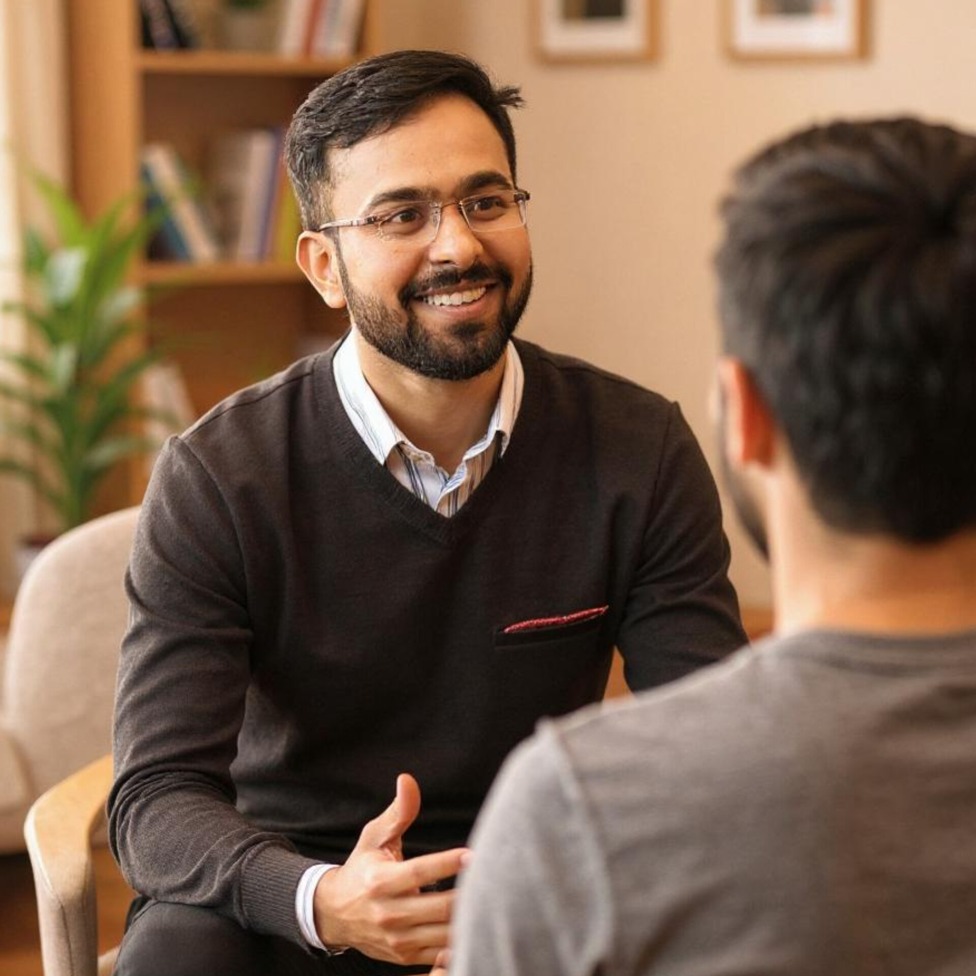 A professional male counselor attentively advising a patient in a cozy counseling room with warm lighting and calm atmosphere